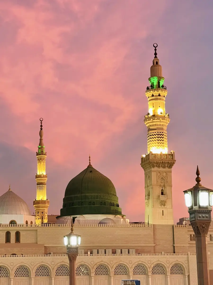 Kubah hijau dan menara Masjid Nabawi di Madinah saat matahari terbenam